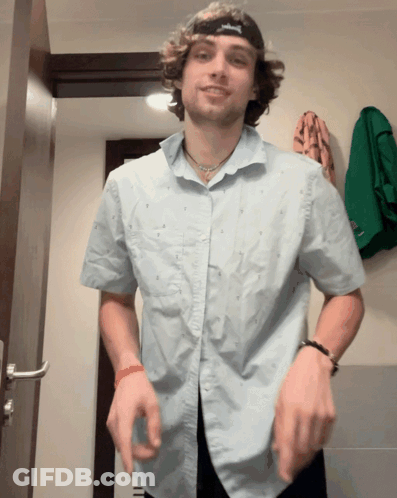 A Man Wearing A Blue Shirt And A Black Hat With A S On It GIF