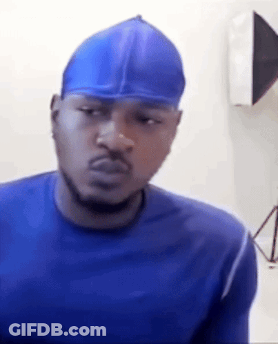 A Man Wearing A Blue Shirt And A Blue Hat Is Making A Funny Face . GIF