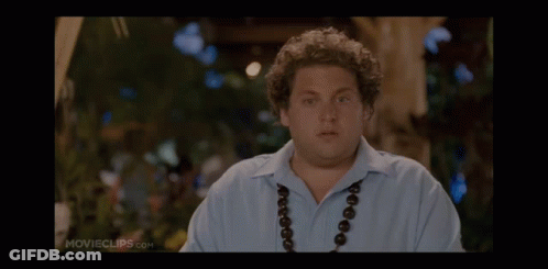 A Man Wearing A Blue Shirt And A Necklace Is On A Movie Clip GIF