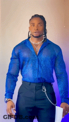 A Man Wearing A Blue Shirt And Black Pants Holds A Piece Of Paper GIF