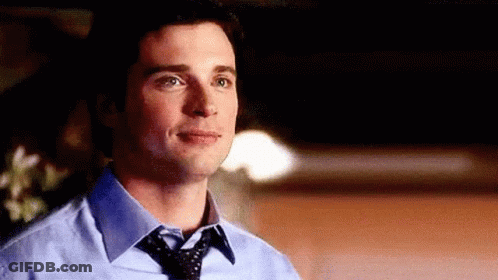 A Man Wearing A Blue Shirt And Tie Is Looking At The Camera . GIF
