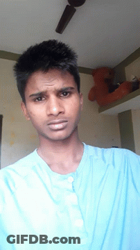 A Man Wearing A Blue Shirt Is Looking At The Camera GIF