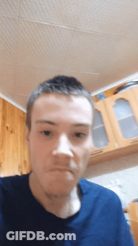 A Man Wearing A Blue Shirt Is Making A Funny Face GIF