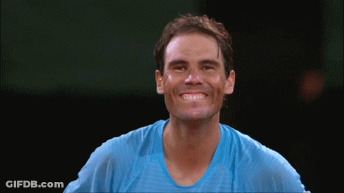 A Man Wearing A Blue Shirt Is Smiling With His Eyes Closed GIF