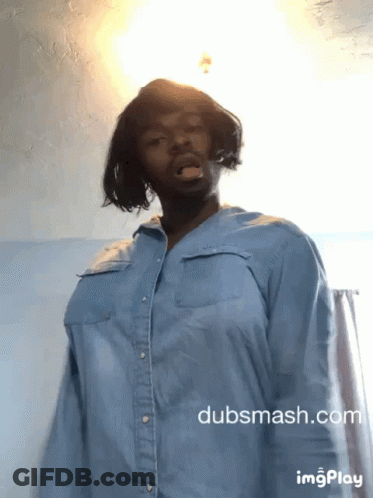 A Man Wearing A Blue Shirt Is Standing In Front Of A Wall With Dubsmash.com Written On The Bottom GIF