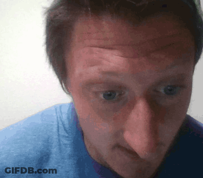 A Man Wearing A Blue Shirt Looks At The Camera GIF