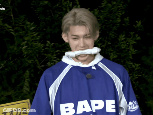 A Man Wearing A Blue Shirt That Says Bape On The Front GIF