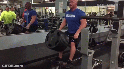A Man Wearing A Blue Shirt That Says Decking Is Lifting A Barbell In A Gym GIF