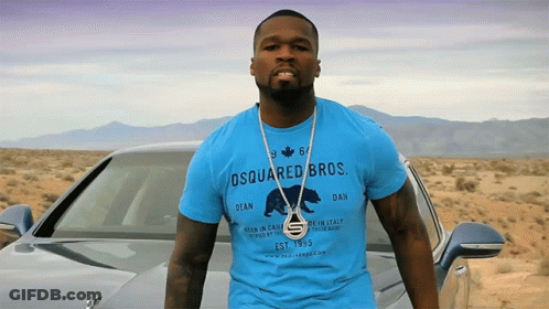 A Man Wearing A Blue Shirt That Says Dsquared Bros Stands In Front Of A Car GIF