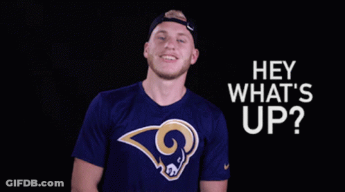 A Man Wearing A Blue Shirt With A Ram On It Is Smiling And Says Hey What 'S Up GIF