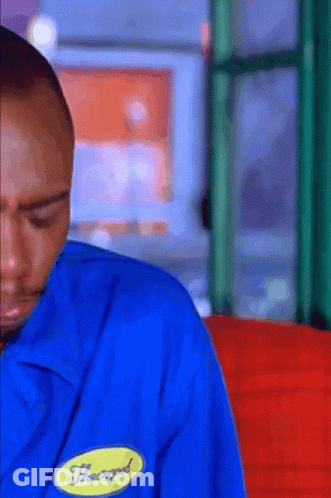 A Man Wearing A Blue Shirt With A Yellow Badge That Says Heavygod On It GIF