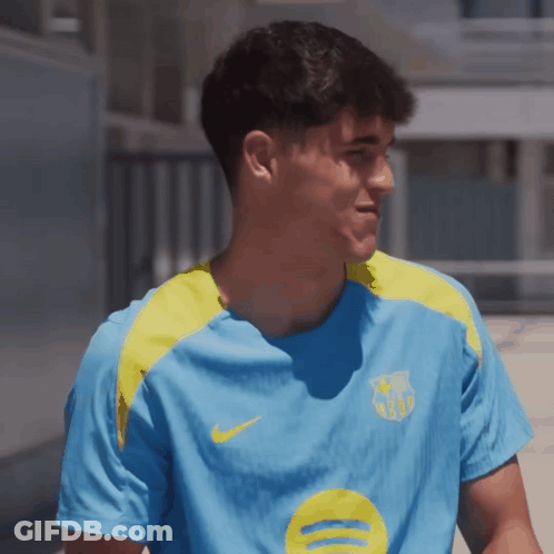 A Man Wearing A Blue Shirt With A Yellow Circle On It GIF