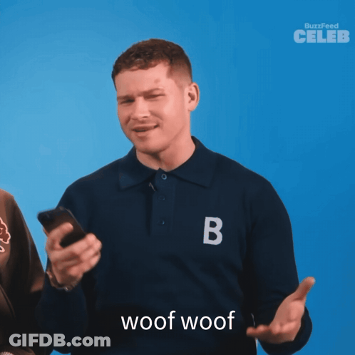 A Man Wearing A Blue Shirt With The Letter B On It Holds A Cell Phone GIF