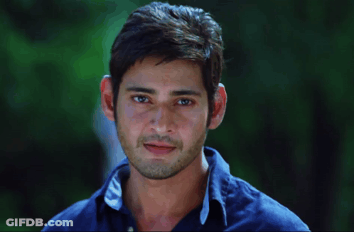 A Man Wearing A Blue Shirt With The Letter C On The Collar Smiles GIF