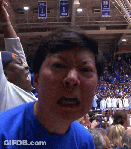 A Man Wearing A Blue Shirt With The Number 1 On It Stands In Front Of A Crowd GIF