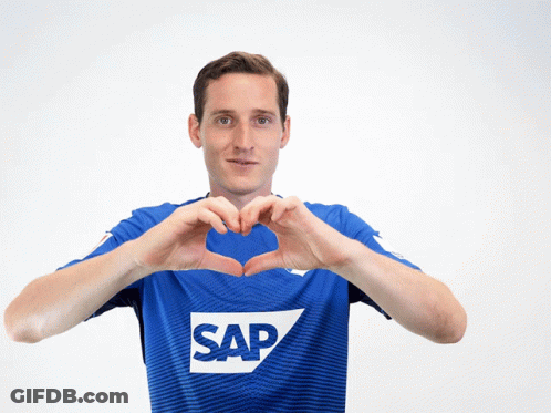 A Man Wearing A Blue Shirt With The Word Sap On It Makes A Heart Shape With His Hands GIF