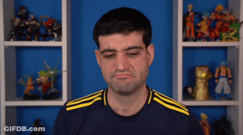 A Man Wearing A Blue Shirt With Yellow Stripes Is Making A Face GIF