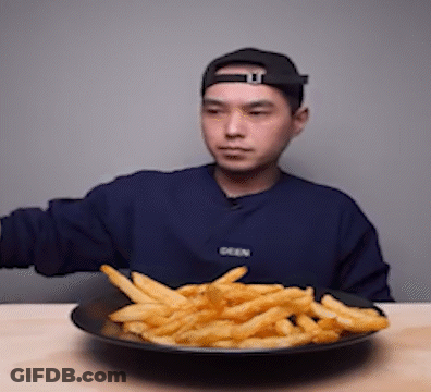 A Man Wearing A Blue Sweater That Says Seen Is Eating French Fries GIF