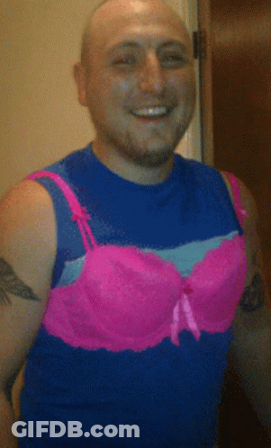 A Man Wearing A Blue Tank Top And Pink Bra GIF