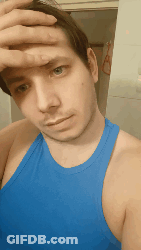 A Man Wearing A Blue Tank Top Wipes His Forehead With His Hand GIF