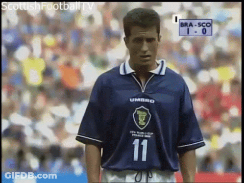 A Man Wearing A Blue Umbro Jersey Stands On A Field GIF