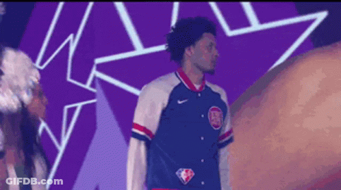 A Man Wearing A Blue White And Red Jacket With The Nba Logo On The Front GIF