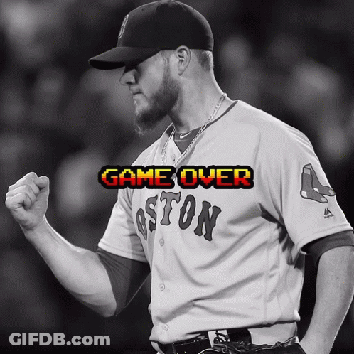 A Man Wearing A Boston Jersey Holds His Fist Up In Celebration GIF