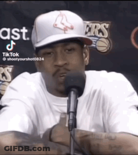 A Man Wearing A Boston Red Sox Hat Is Sitting In Front Of A Microphone GIF