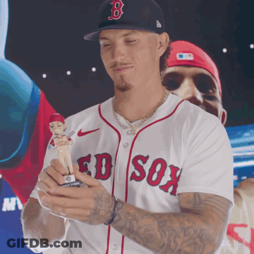 A Man Wearing A Boston Red Sox Jersey Holds A Baseball Figure GIF