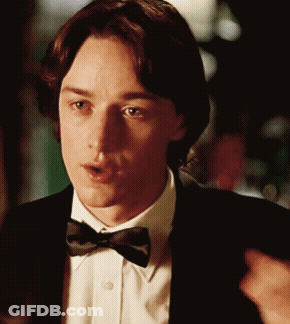 A Man Wearing A Bow Tie And A Suit Looks At Something GIF