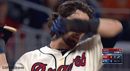 A Man Wearing A Braves Jersey Covers His Eyes GIF