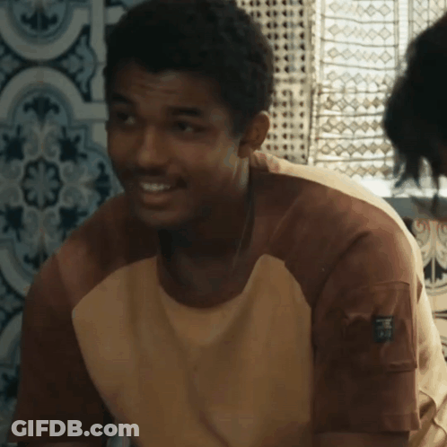 A Man Wearing A Brown And White Shirt With A Pocket On The Sleeve That Says ' R.i.p. ' GIF