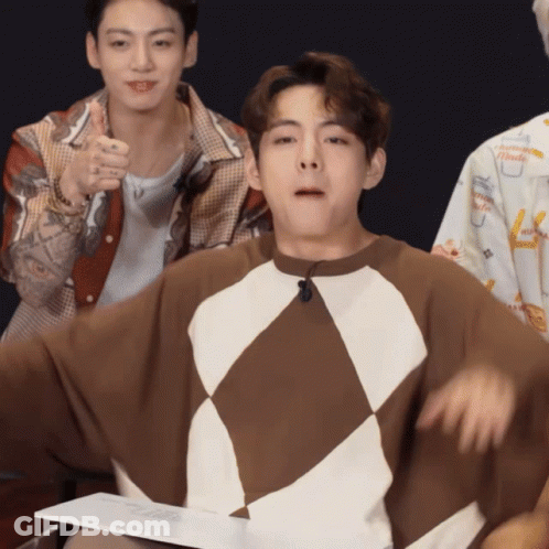 A Man Wearing A Brown And White Sweater With A Microphone On His Neck GIF