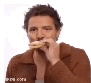 A Man Wearing A Brown Jacket Is Eating A Sandwich . GIF