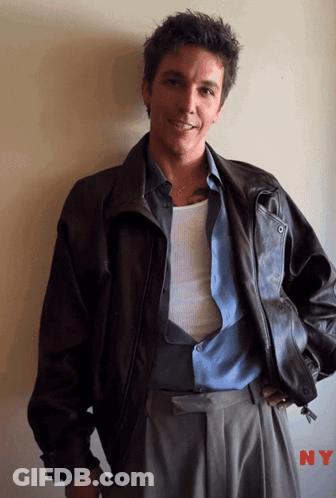 A Man Wearing A Brown Leather Jacket And A Blue Shirt With Ny Written On The Bottom GIF