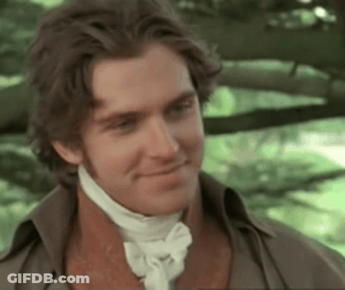 A Man Wearing A Brown Shirt And A White Tie Smiles GIF