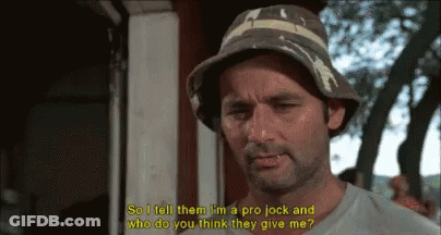 A Man Wearing A Bucket Hat Is Talking To Another Man . GIF