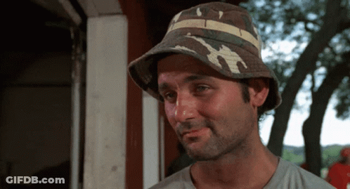 A Man Wearing A Bucket Hat With A Striped Band GIF