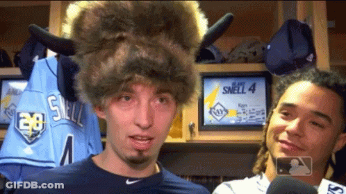 A Man Wearing A Buffalo Hat Is Standing Next To A Man Wearing A Jersey That Says Smell 4 GIF