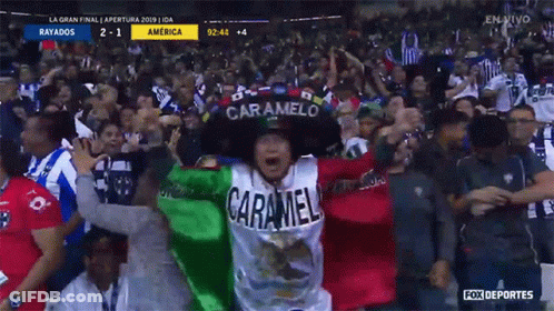 A Man Wearing A Caramelo Hat Stands In A Crowd At A Soccer Game GIF