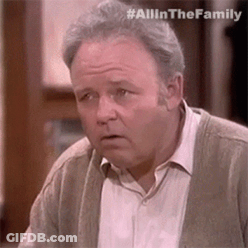 Man In Cardigan And White Shirt Looking At Camera GIF