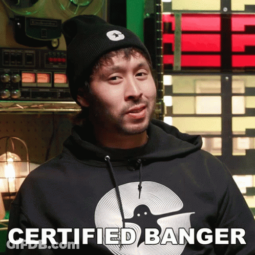 A Man Wearing A Certified Banger Hoodie Stands In Front Of A Record Player GIF