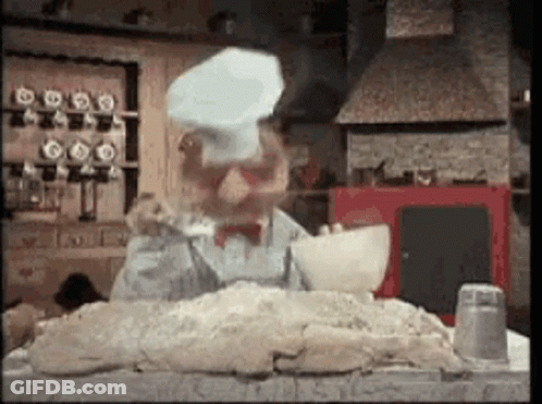 A Man Wearing A Chef 'S Hat Is Standing Over A Pile Of Dough . GIF