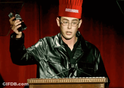 A Man Wearing A Chef 'S Hat With Bertha On It Stands At A Podium GIF
