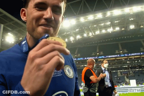 A Man Wearing A Chelsea Jersey Holds A Medal In His Hand GIF