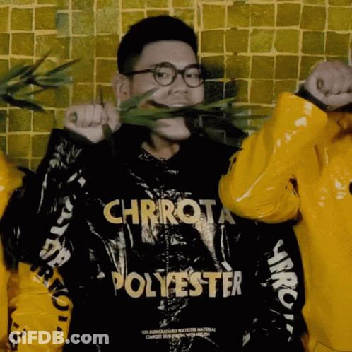 A Man Wearing A Chrrot Polyester Jacket Holds A Plant In His Mouth GIF