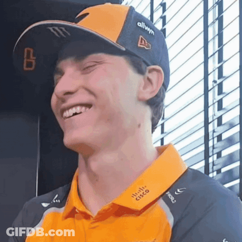A Man Wearing A Cisco Shirt And A Hat Is Smiling GIF