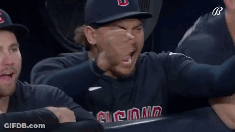 A Man Wearing A Cleveland Baseball Uniform Is Holding His Fist Up In The Air GIF