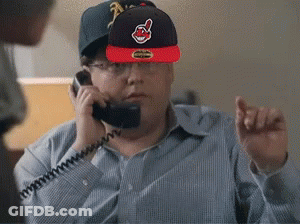 A Man Wearing A Cleveland Indians Hat Talks On A Phone GIF