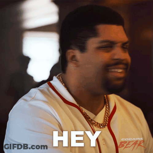 A Man Wearing A Cocaine Gear Shirt Is Smiling And Saying Hey GIF